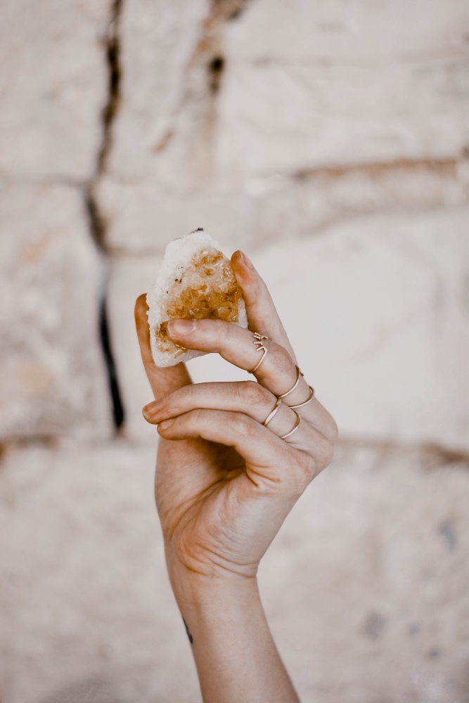 A hand holding a crystal.