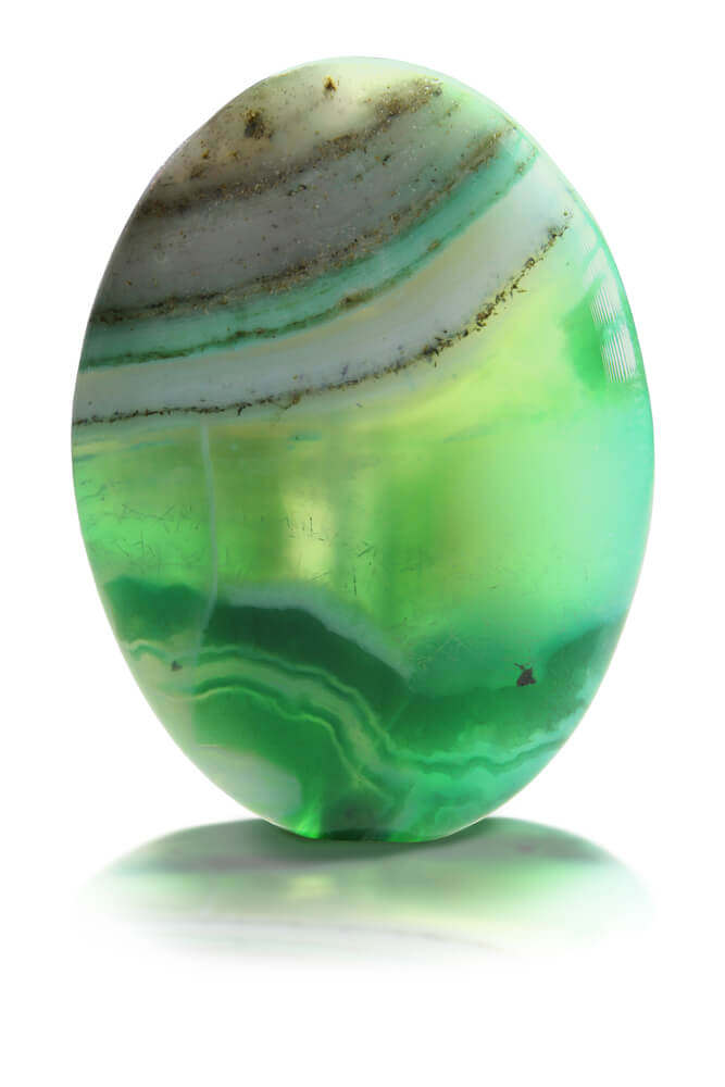 A green gemstone with stripes of white and brown.