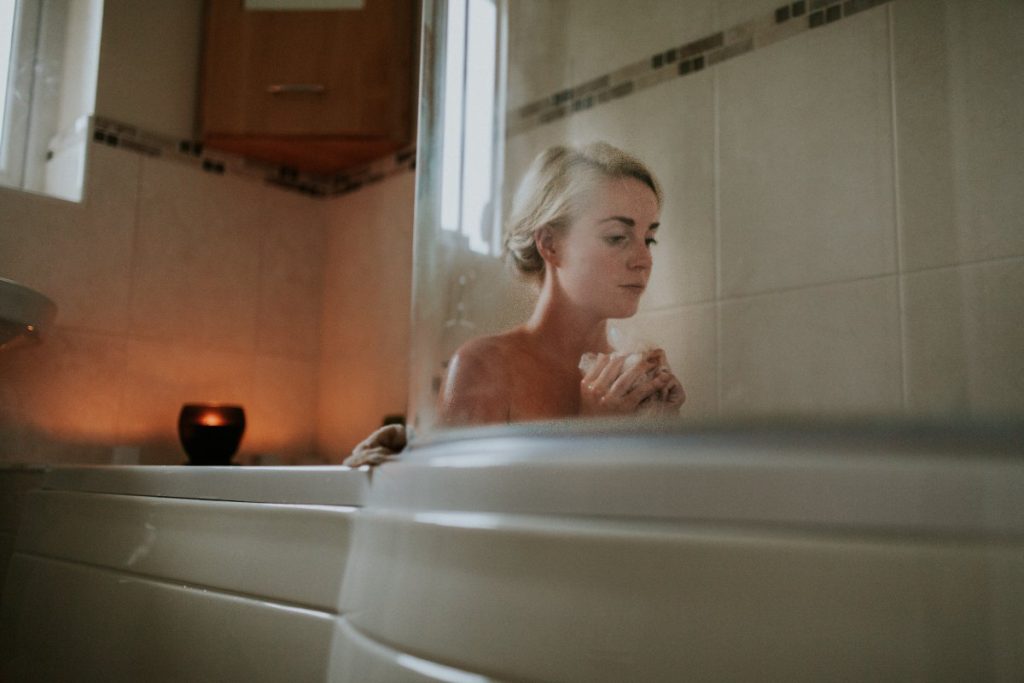 Woman having a bath with a candle lit